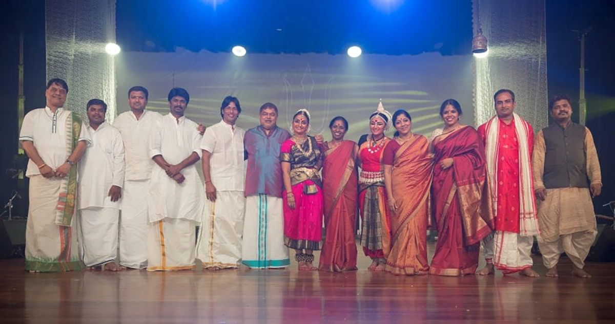 Dato Sri standing on stage with traditional dancers in traditional outfit