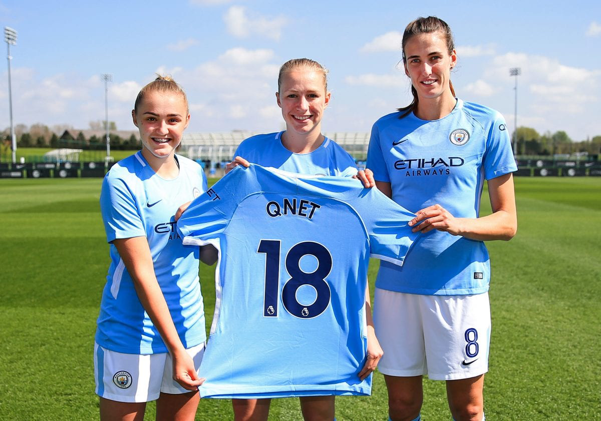 Qnet Is Proud To Be The Official Direct Selling Partner Of Manchester City Women’s Team 2 3 women footbal players holding QNET jersey