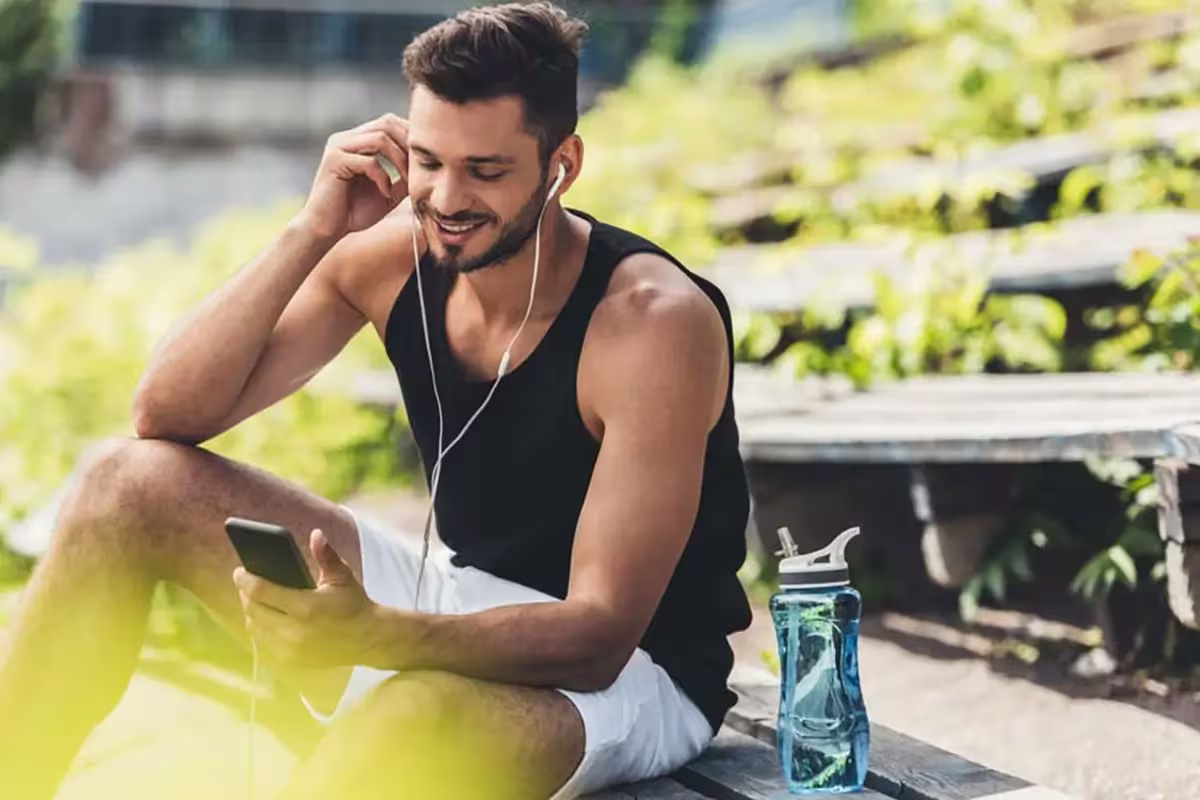 Homepure Viva: Championing Your Biggest Resolutions For A Remarkable New Year 2 Man sits down to listen to adjust his earphones and sets down his water jug beside him on the bench