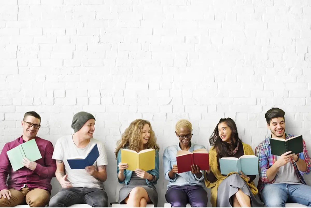 group of people sitting down reading books