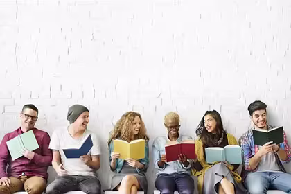 people sitting together reading a book