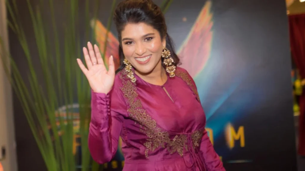 Sharfun Shaikh waving her hand smilling