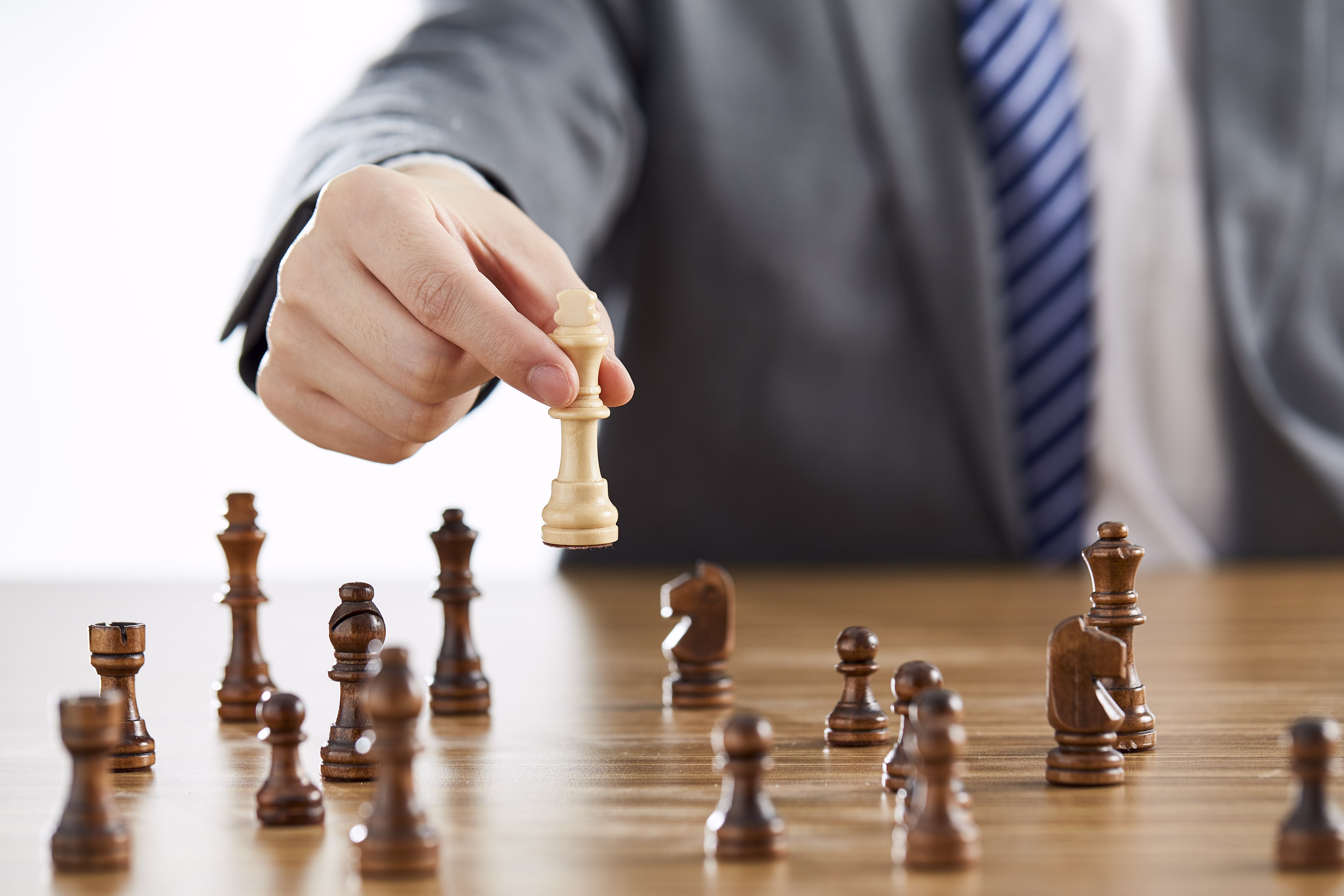 What Type Of Entrepreneur Are You? 2 A businessman in a suit playing chess and about to win, reflecting the qualities of a strategic entrepreneurial leader.