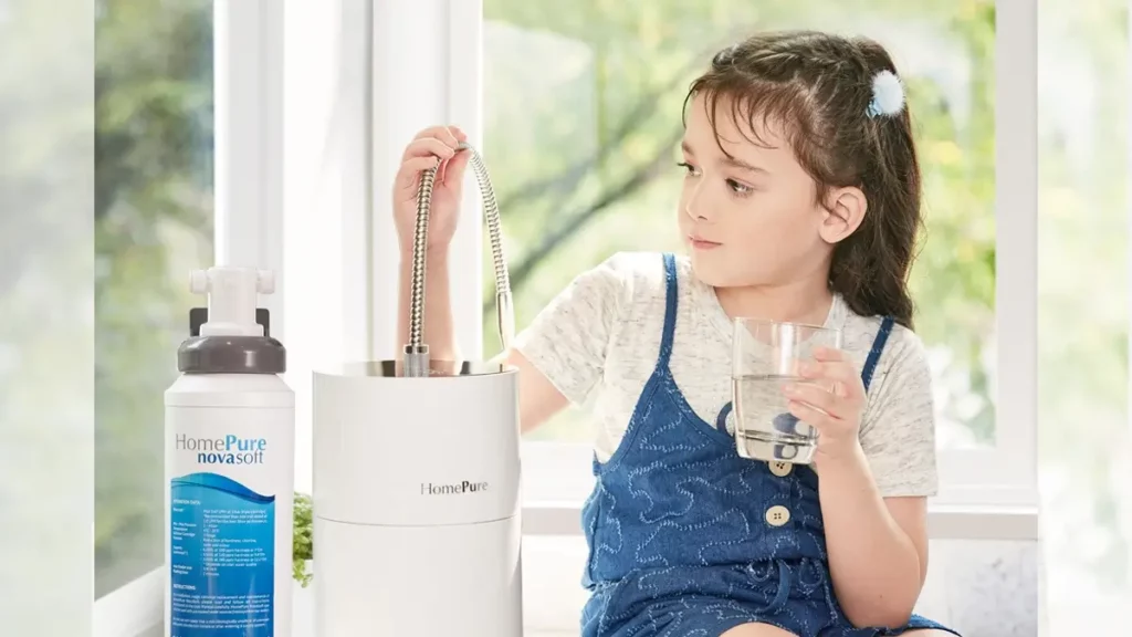 A girl seated, hydrating with HomePure, while reaching for the adjacent HomePure-NovaSoft-Solution-To-Hard-Water