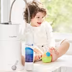 A joyful toddler on a table with toy, alongside HomePure Viva, encouraging a cheerful and healthful lifestyle.