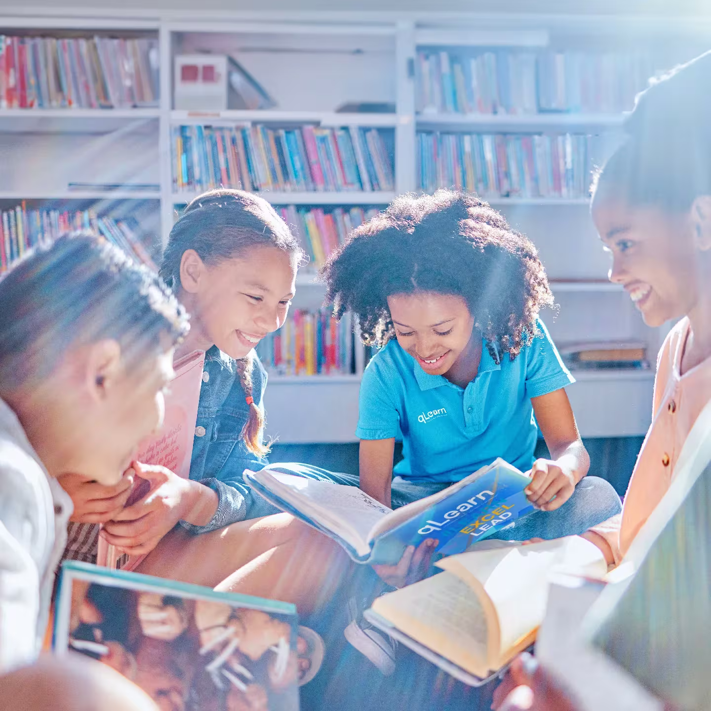 How Qnet Products And Services Are Championing Health And Bettering People’s Lives 5 Kids huddled together as they read books for their qLearn course