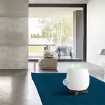 A stunning living space featuring a white and marble decor, with a HomePure Zayn unit on a blue carpet for indoor air pollution control.