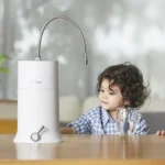 A young boy beside a kitchen counter, with a glass of water nearby, and a HomePure product on the table.
