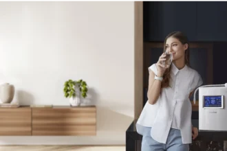 Woman standing next to homepure viva drinking water in kitchen
