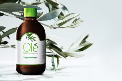 Bottle of Ole Olive Leaf Extract in front of olive leaves