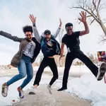Three friends jumping in the air from the joy of experiencing QNET Products