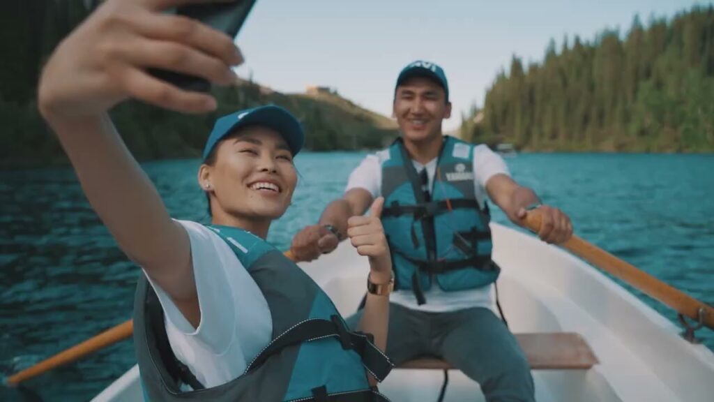Here Are All The Reasons Why People Join Qnet 3 A couple wearing QVI caps and life vests, taking a selfie on a rowboat, after they won the Remember Your Why QNET Contest