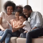 Family sitting on couch smiling