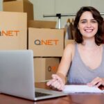 Girl smiling in front of boxes for her micro, small and medium-sized enterprise