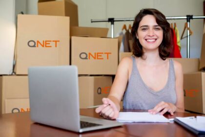 Girl smiling in front of boxes for her micro, small and medium-sized enterprise