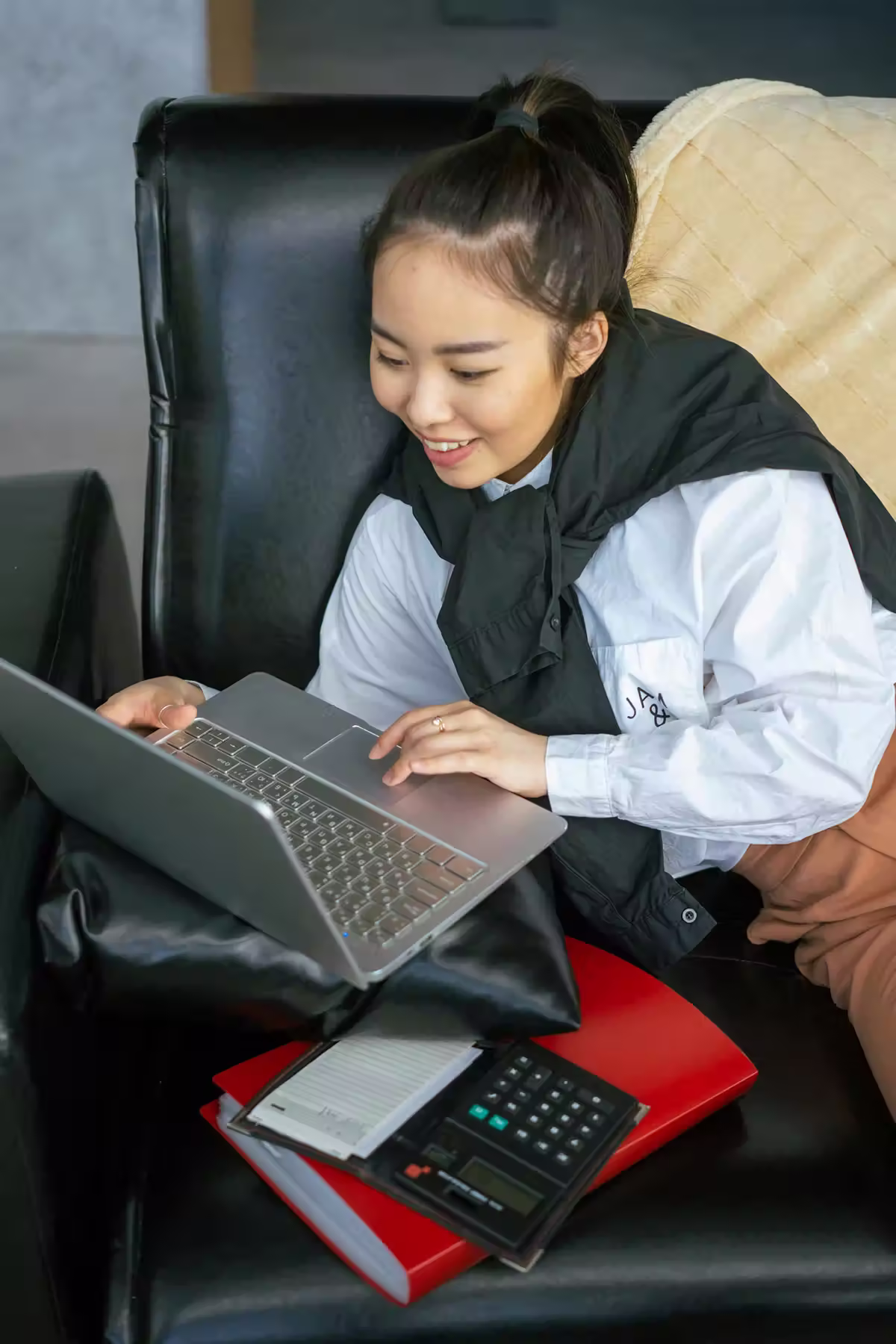 How To Manage Your Qnet Earnings 3 Girl looking at laptop with calculator beside her so she can calculate her QNET earnings