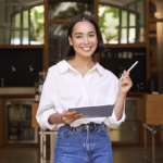 What is Micro-Entrepreneurship? Woman holds up a tablet and pen in front of a nice venue