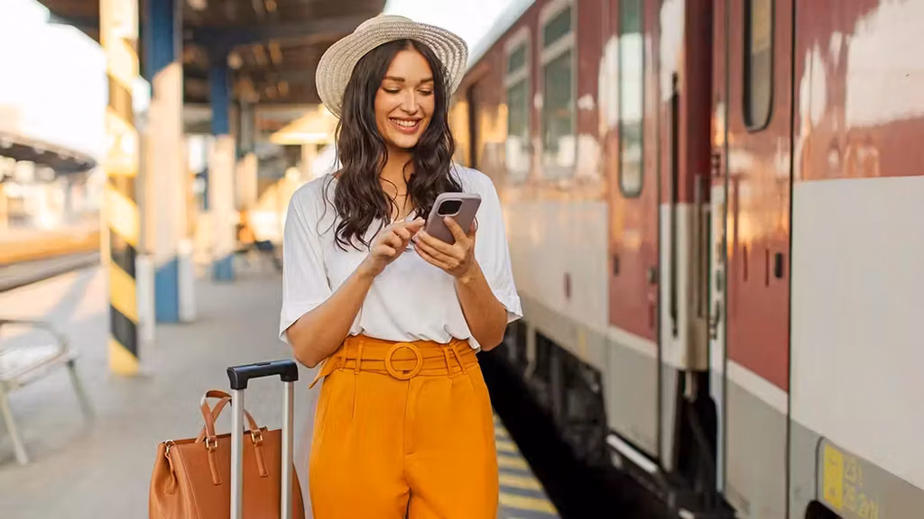 Inside Qvi, Qnet'S Gateway To Extraordinary Travel Experiences For The Modern Traveller 2 Girl at train station checking her QVI holiday app